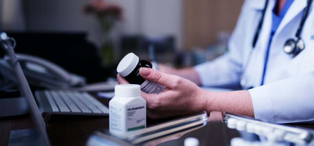 Doctor checking two drugs for interactions using his computer