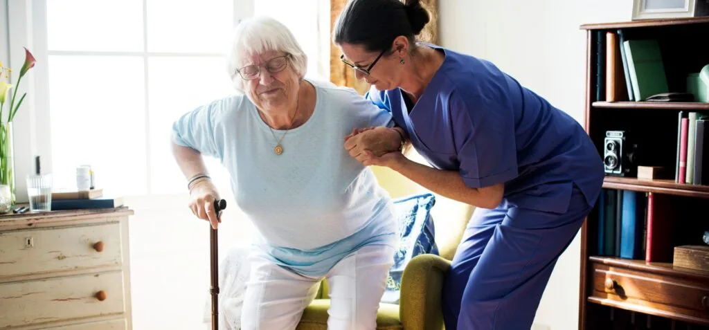Nurse helping senior woman to stand