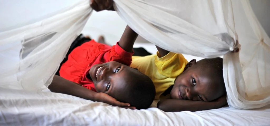 Twins Dorcas and Deborah Bendak, 7, under their old mosquito net at their home in Musoma. They both received a new mosquito net at Iringo B primary school.